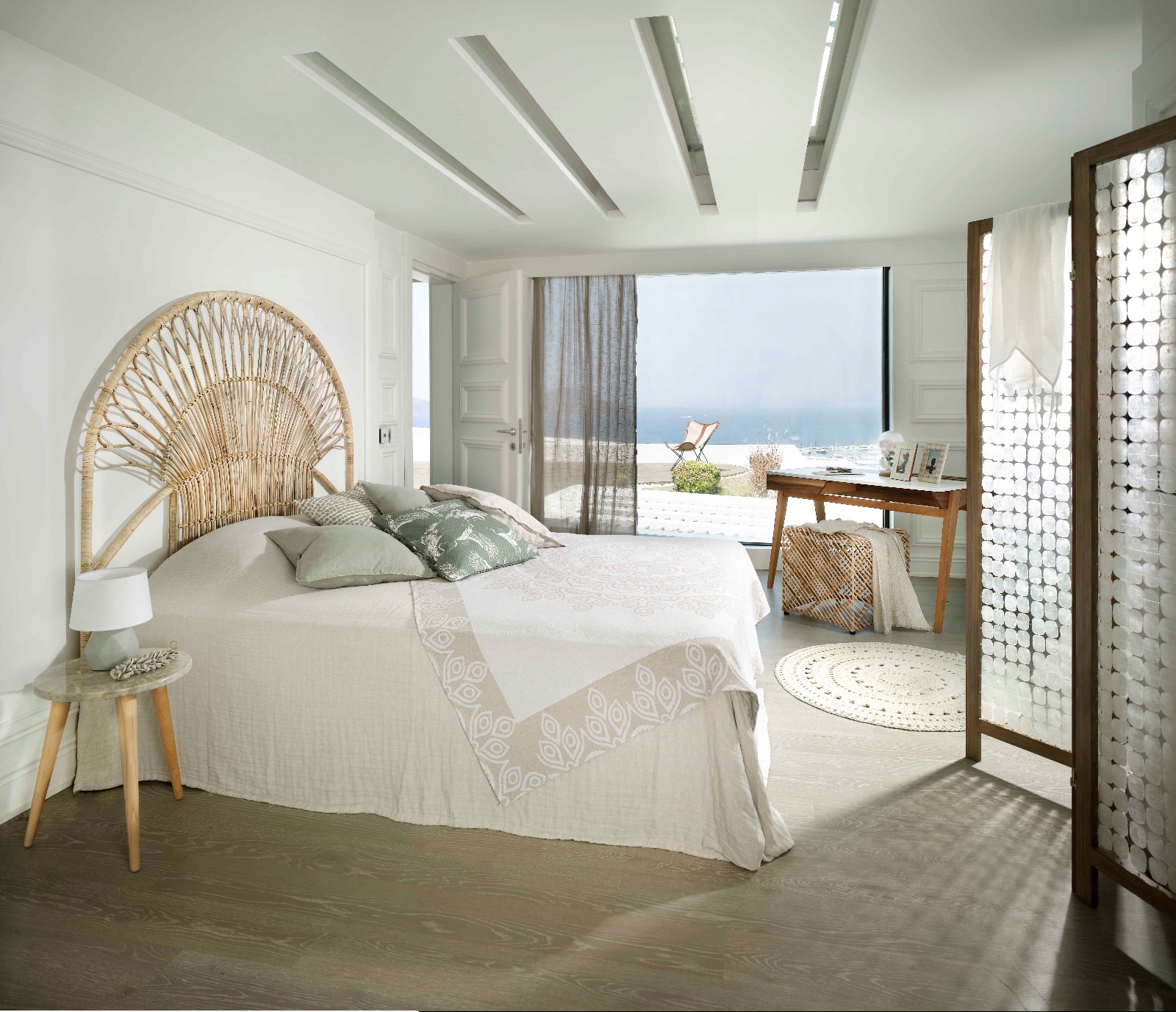 Luxury villa bedroom in neutral tones with a double bed, linen curtains and morning light